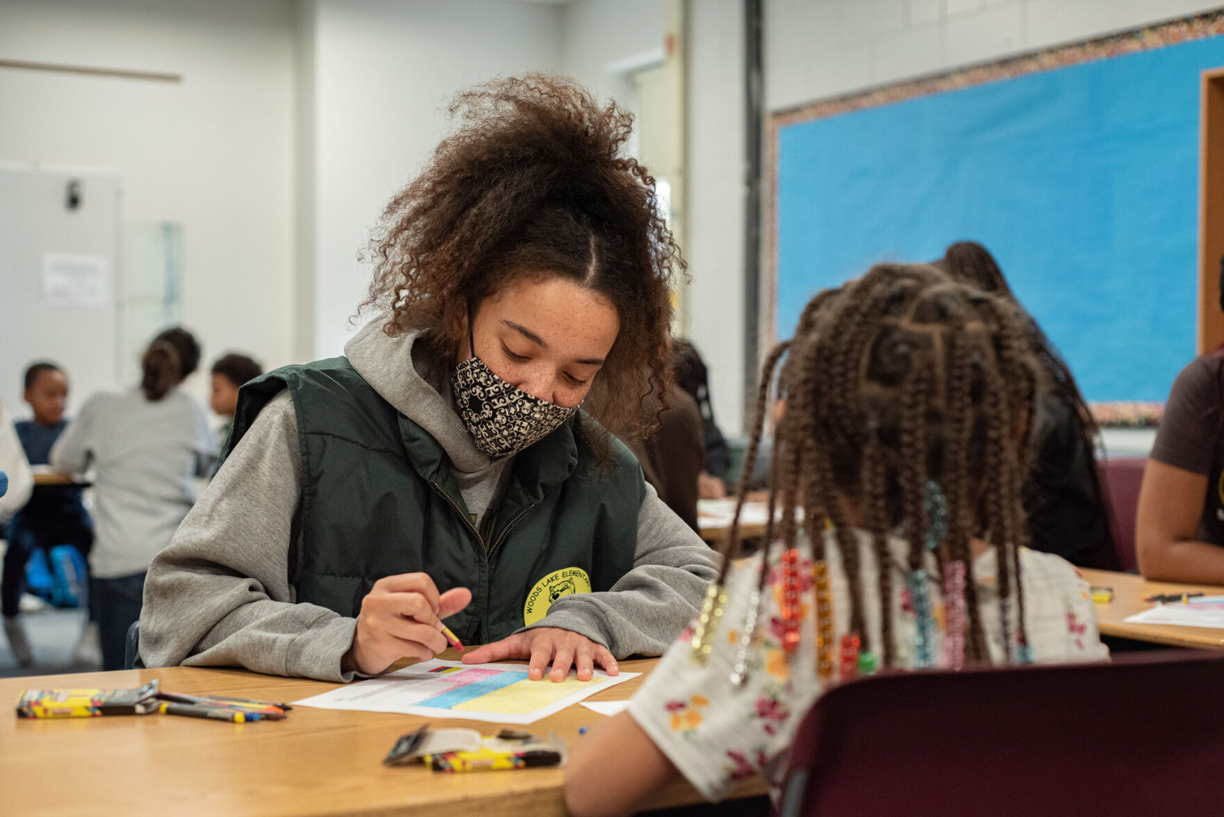 UNIDOS volunteer makes craft with elementary student